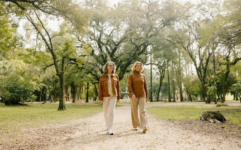 Two women walking on a path in a park