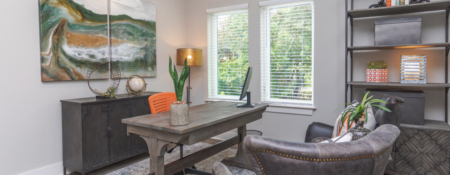 an office with a desk, chairs and a window