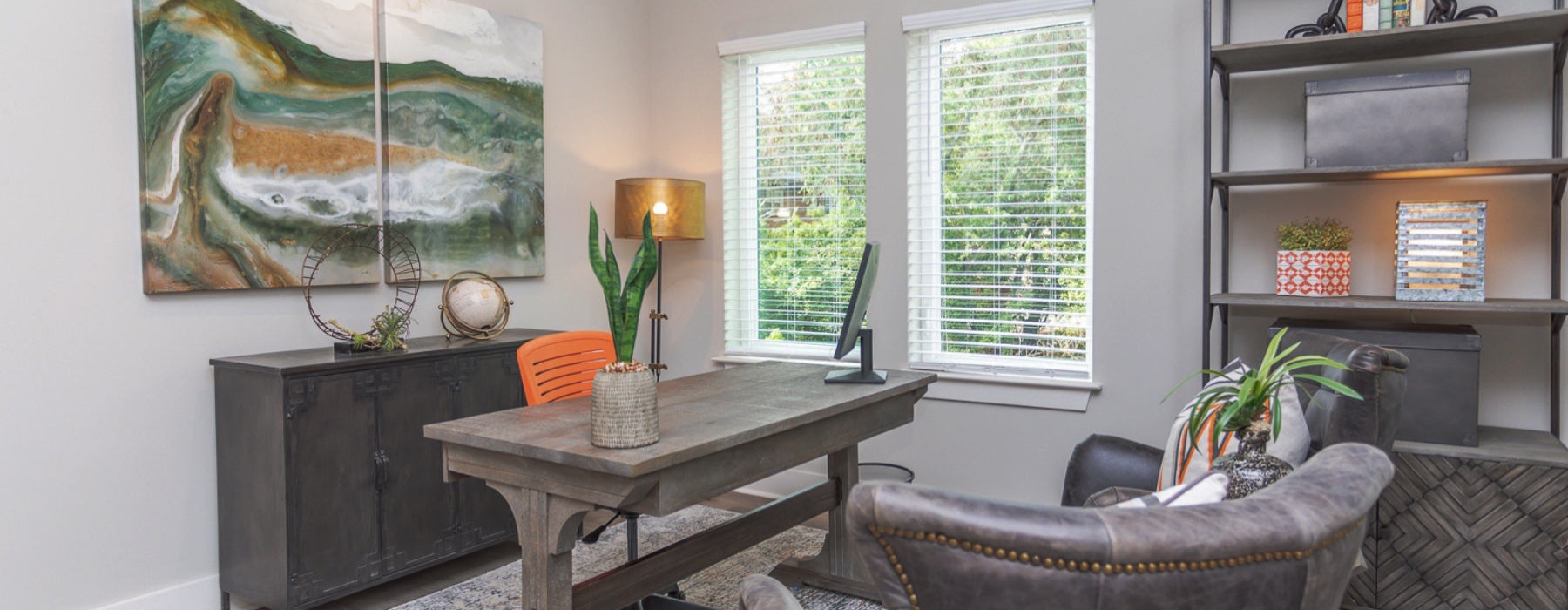 an office with a desk, chairs and a window